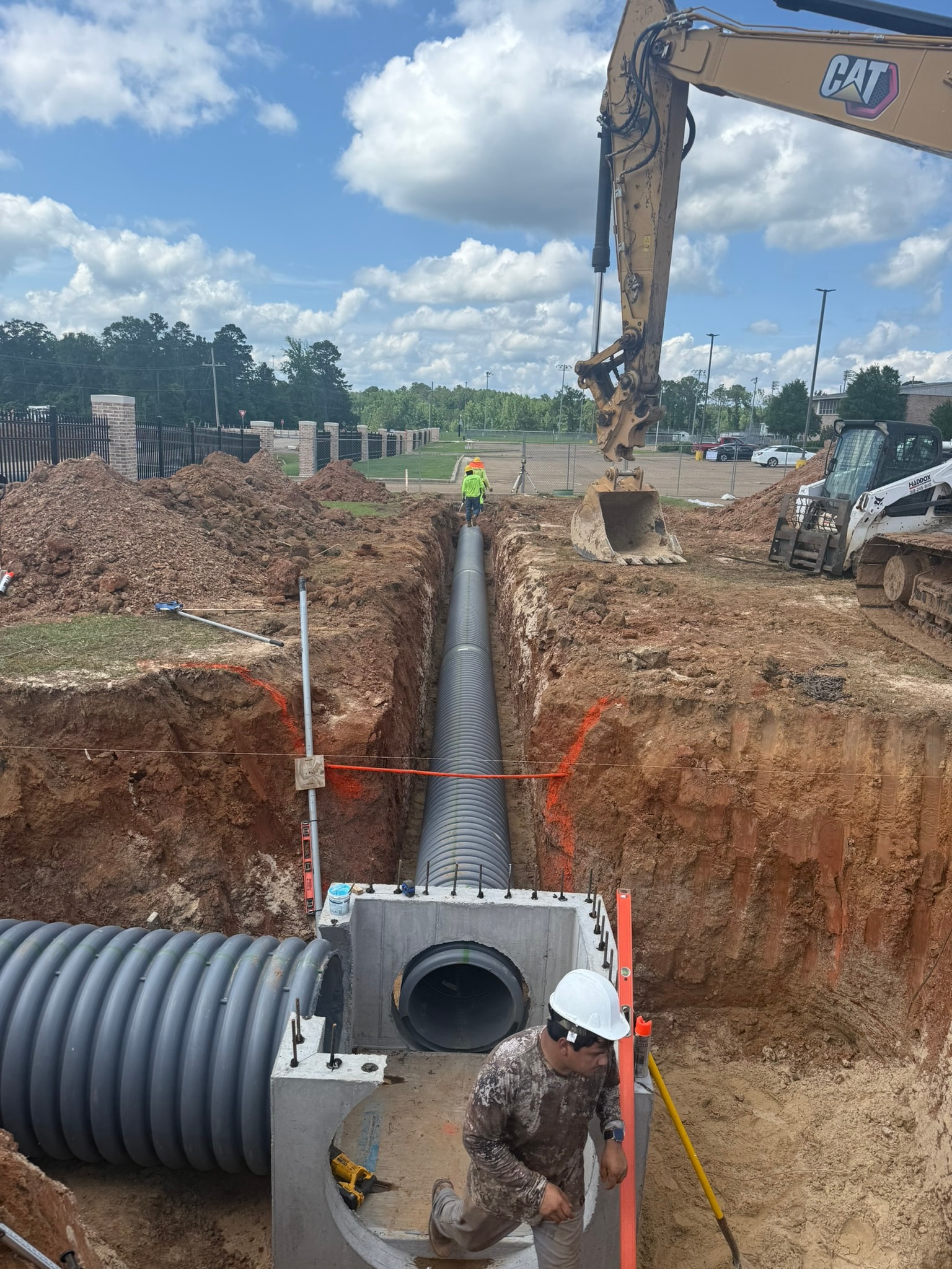 Corrugated pipe meeting concrete catch basin wall, close-up connection detail