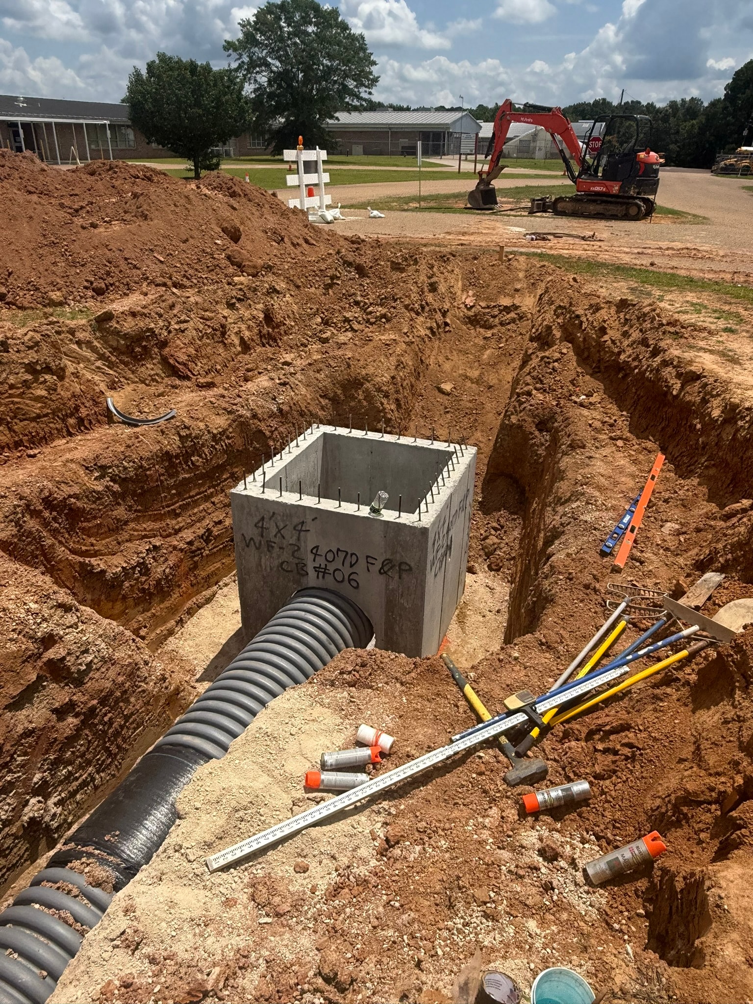 Catch basin CB-06 close-up with corrugated pipe seated in concrete base