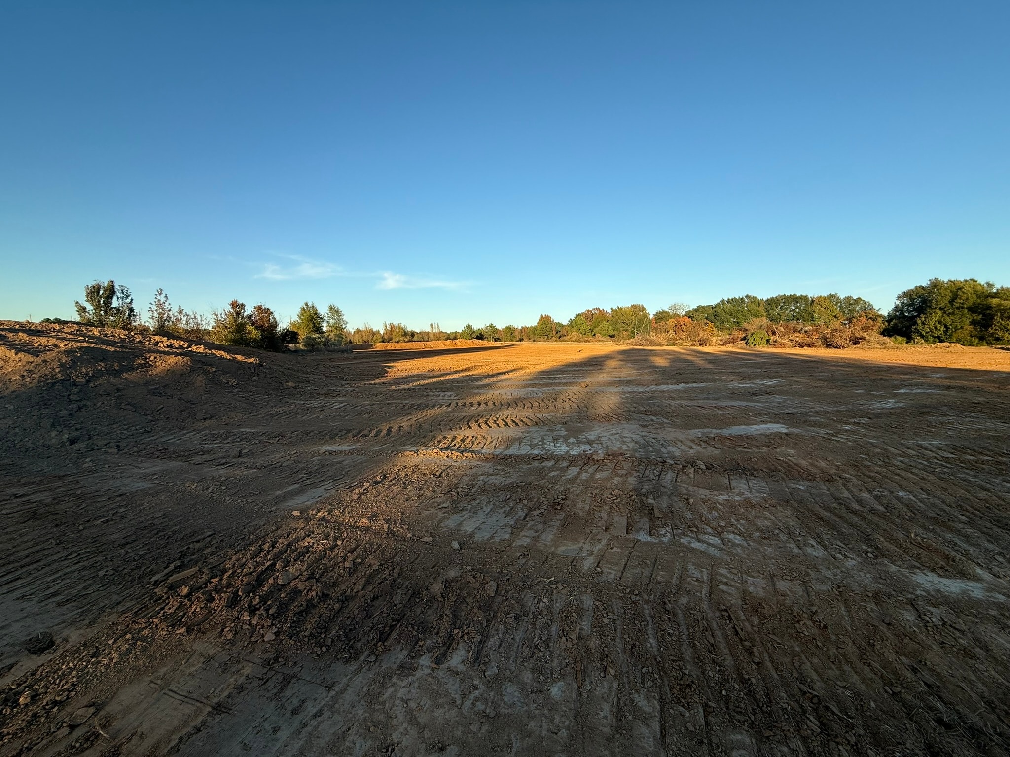 Wide trench with drainage pipe and concrete forms in background